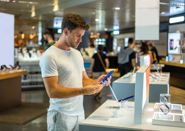 Buyer with smartphone in electronics shop