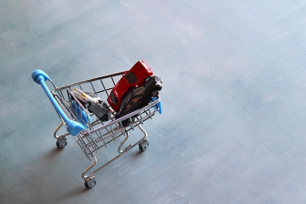 Buying car, car sales and car ownership concept. Cars in shopping trolley