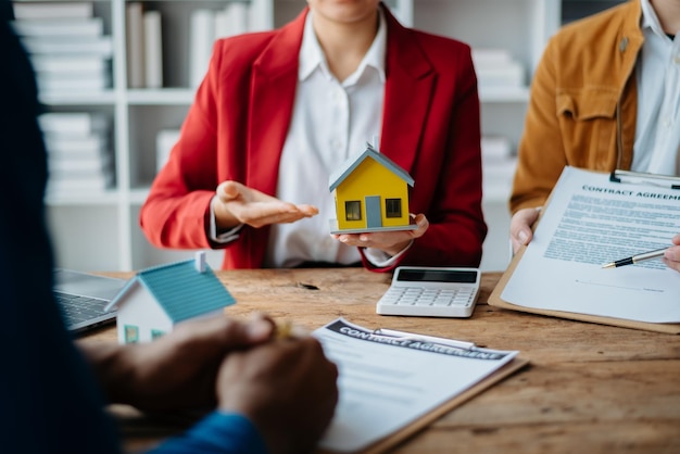 Buying a home or insurance deal an insurance agent pointing a pen to those interested in renting a house a contract signing an Home buying agreement in officexA