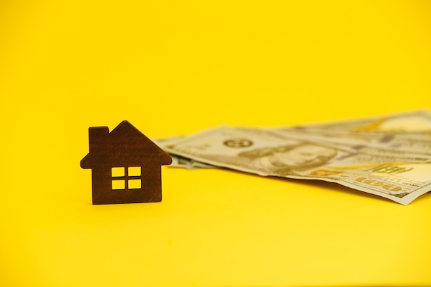 Buying house concept. Legal mortgage. Hose with money on the yellow table.