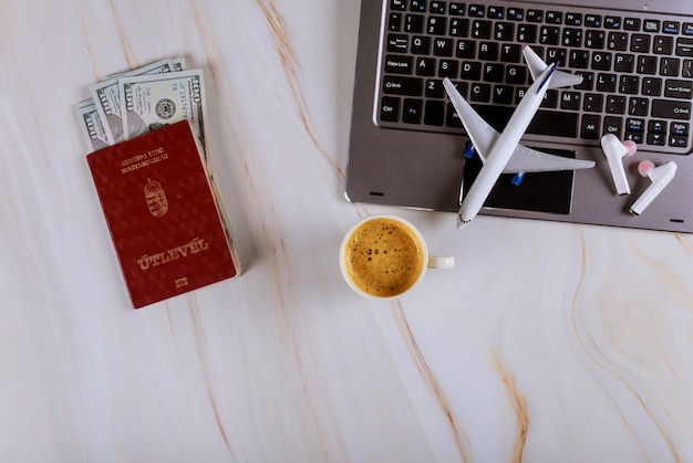 Buying tickets online at airplane booking with computer and Hungarian passports and dollar banknotes