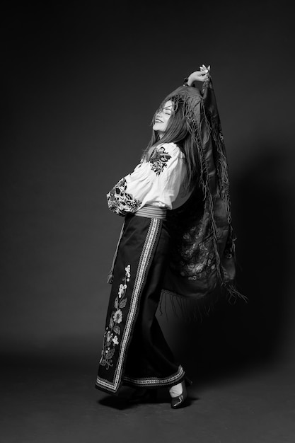 BW portret van Oekraïense vrouw in traditionele etnische kleding en bloemen rode krans op studio achtergrond draait een zakdoek Oekraïense nationale geborduurde jurk oproep vyshyvanka