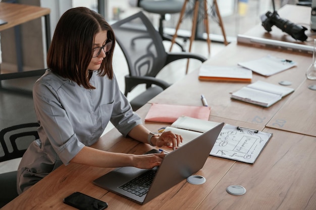 By the laptop on table Female doctor in coat is indoors