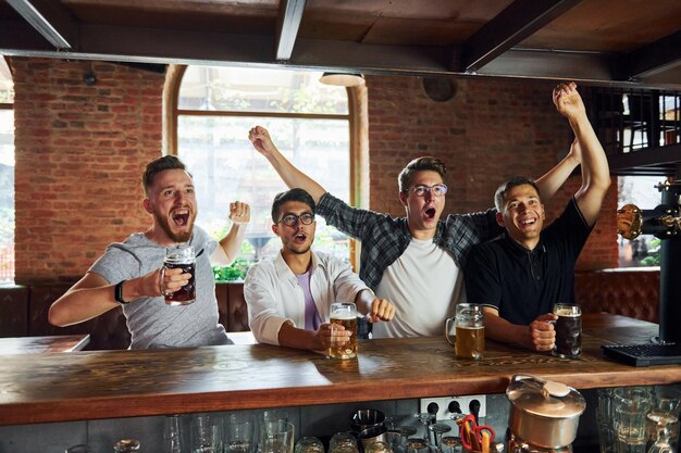 By the table People in casual clothes sitting in the pub