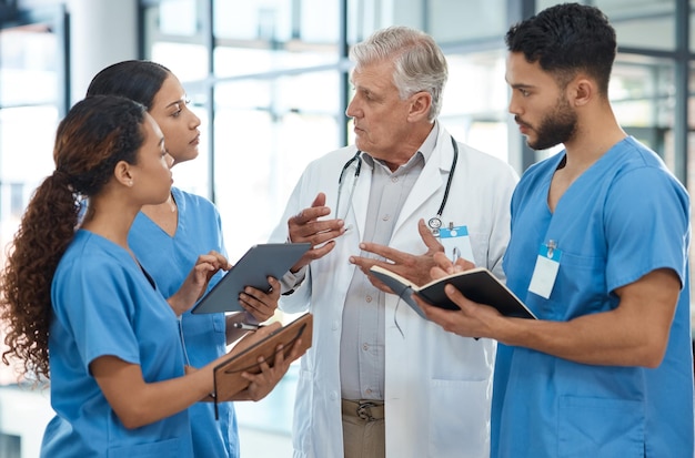 By working together, we support and learn from each other. Shot of a group of medical practitioners having a discussion in a hospital.