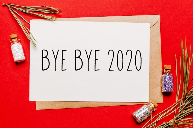 Bye bye 2020 christmas note with fir branch on red New Year concept