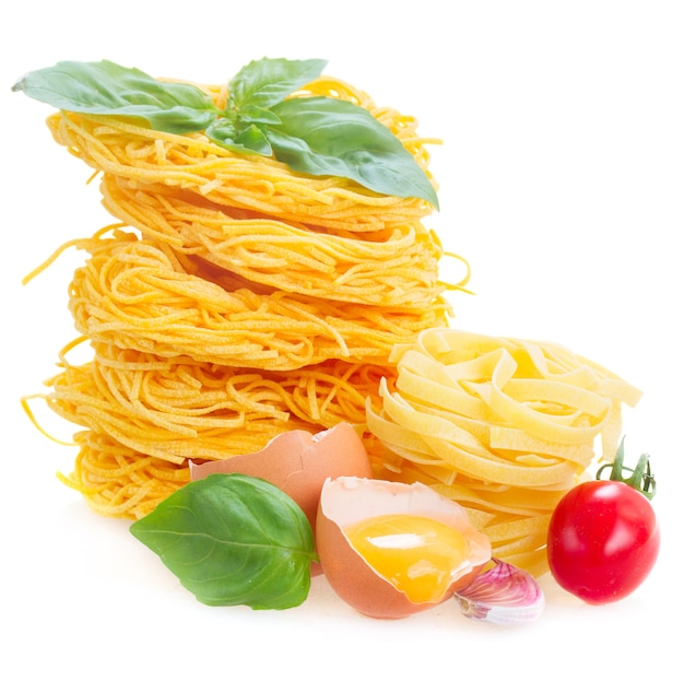 C rauwe pasta met ei en tomaat geïsoleerd op wit