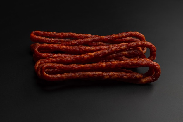 Cabanossi, dry sausage isolated on a black background.