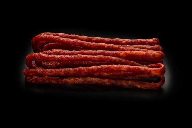 Photo cabanossi dry sausage isolated on a black background
