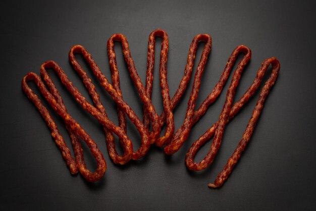 Cabanossi dry sausage isolated on a black background