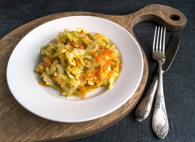 Cabbage braised in white plate on black background