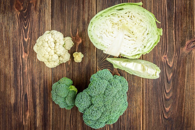 Cavolo, broccoli e cavolfiore su fondo in legno.