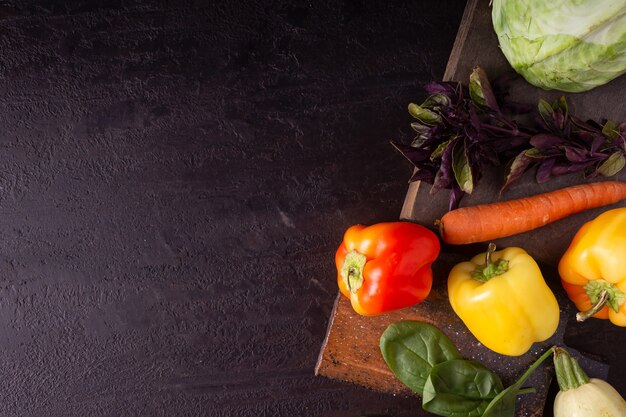 Cabbage peppers zucchini greens carrots on a wooden board space for text