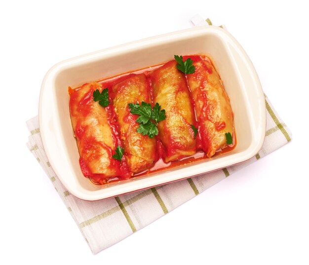 Cabbage rolls stuffed with ground beef and rice with sour cream in a baking dish