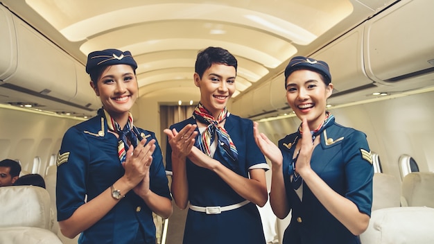 Cabin crew clapping hands in airplane . Airline transportation and tourism concept.