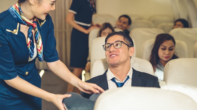 Cabin crew give service to passenger in airplane