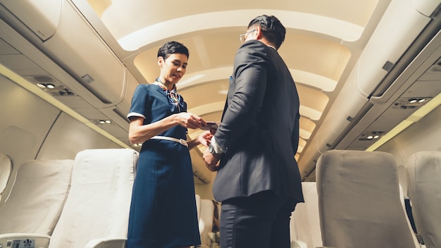 Photo cabin crew greeting passenger in airplane