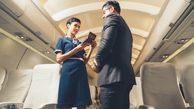 Cabin crew greeting passenger in airplane