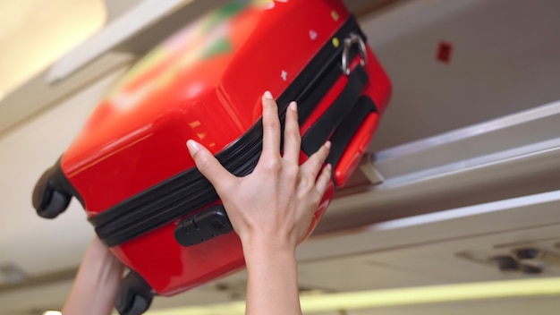 Cabin crew lifting luggage in airplane