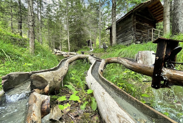 木の丸太の小さな滝のある森の小屋