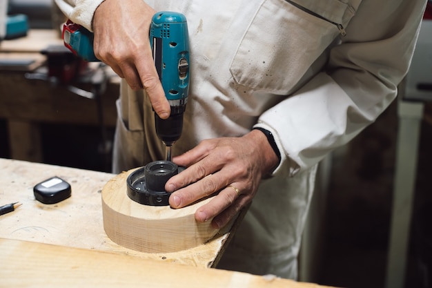 Ebanista che avvita un pezzo di legno