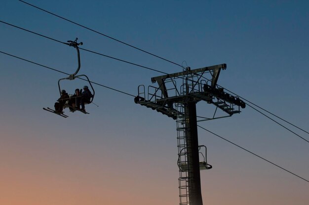 Cable car on sky resort against evening sky, silhouette shot