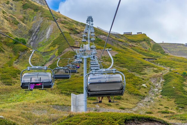 写真 山と空の背景に人々が乗っているケーブルカー