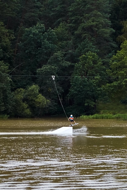 Cable wakeboarding is extreme water sport Man makes an jump on wakeboard Active lifestyle