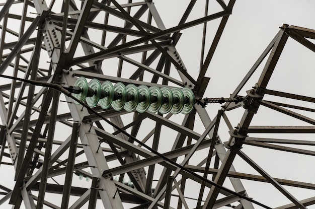 Cables and modular suspension insulators for overhead power line Transmission tower Metal construction The sky in the fog gray gloomy day Industry as a cause of environmental pollution