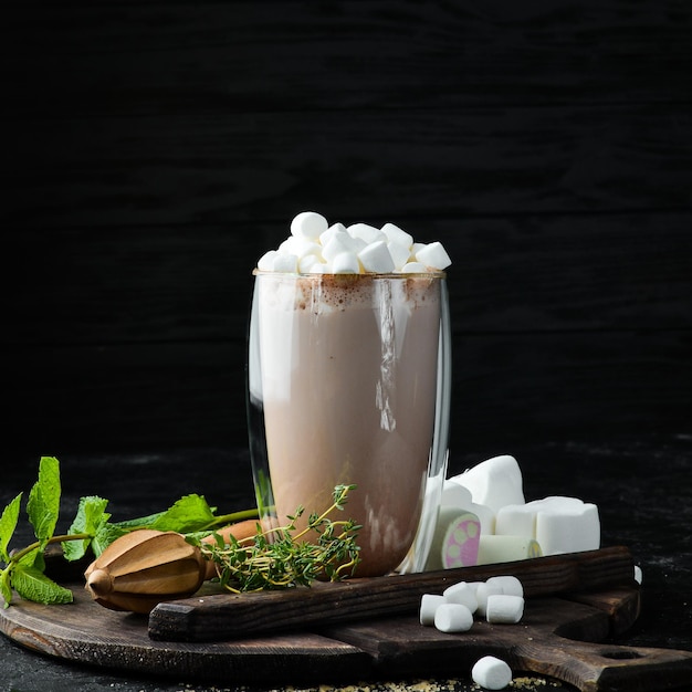 Cacao met melk en marshmallows In het glas Bovenaanzicht Op een zwarte achtergrond