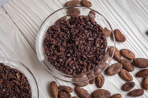 Cacao nibs with cacao beans on old wooden background