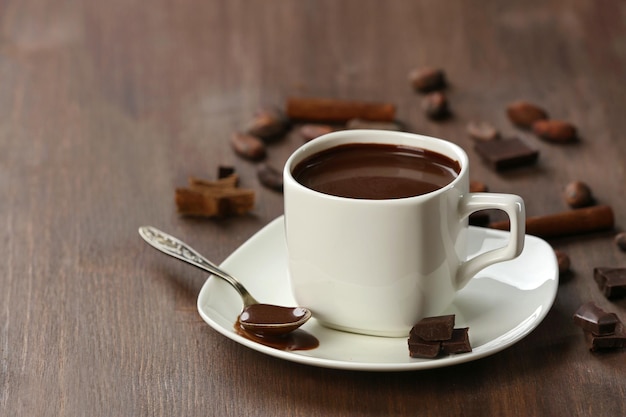 Cacao with chocolate and cinnamon on wooden table