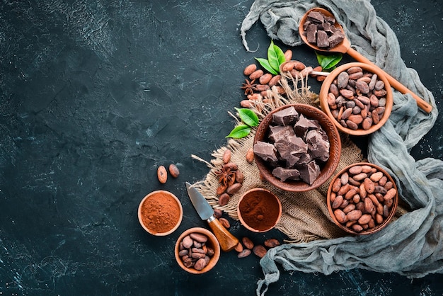 Cacaobonen chocolade cacaoboter en cacaopoeder op een zwarte achtergrond Bovenaanzicht Gratis kopieerruimte