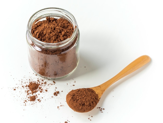 Cacaopoeder op een lepel en een pot