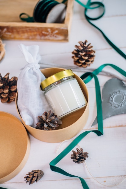 Cadeau in een doos voor kerstkaars met houten lont in glas en geurzakje