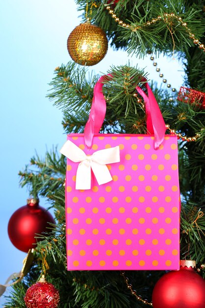 Cadeau op kerstboom op gekleurde achtergrond
