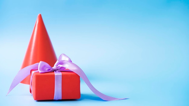 Cadeau verpakt in rood inpakpapier en lint op een blauwe achtergrond close-up.