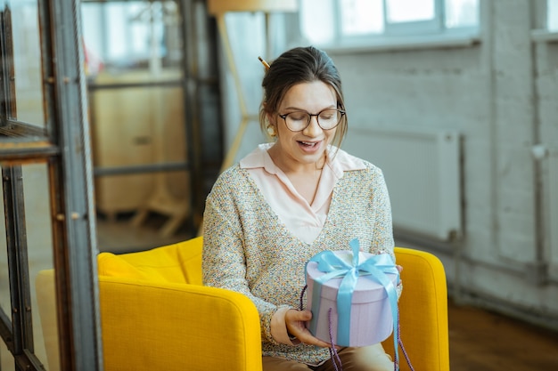 Cadeautje van echtgenoot. zwangere vrouw voelt zich verrast na ontvangst van cadeau van haar man