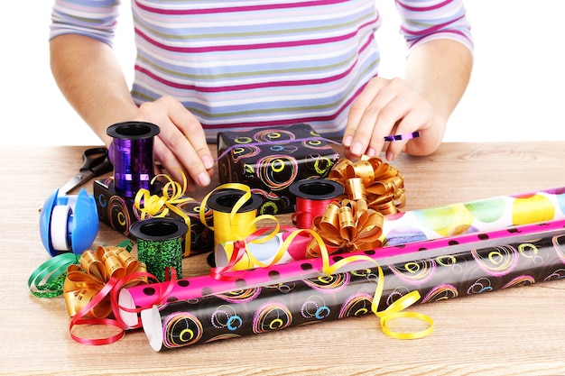 Cadeautjes inpakken omringd door papier, lint en strikken