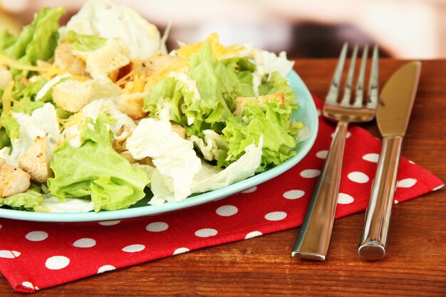 Caesar salad on blue plate on bright background