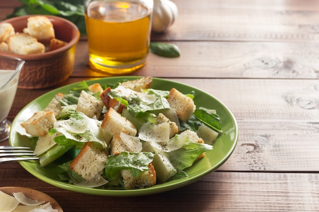 Caesar salad and ingredients at wooden 