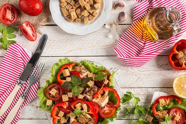 Caesar salad on rustic surface with ingredients