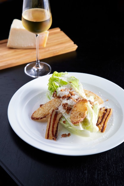 Caesar salad sul piatto bianco sulla tavola nera