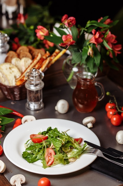 Салат Цезарь с курицей, помидорами черри, листьями салата.