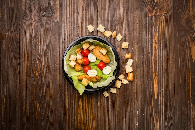 Insalata caesar con pollo pomodorini e uova di quaglia su un piatto