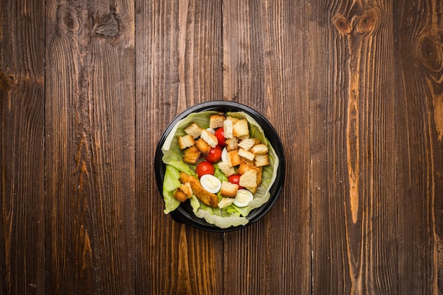 Insalata caesar con pollo pomodorini e uova di quaglia su un piatto