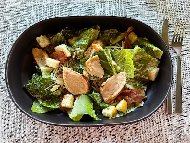 Caesar salad with chicken fillet bacon and croutons traditional Italian food close up