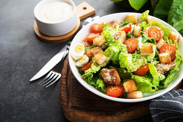 Caesar salad with chicken fillet, cherry tomatoes and croutons, traditional Italian food, copy space