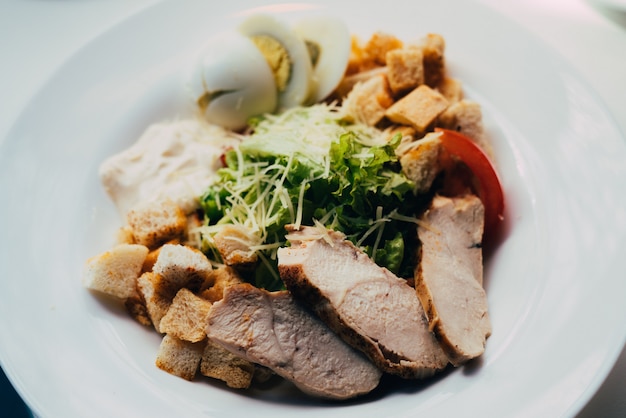 Caesar salad with chicken on the plate