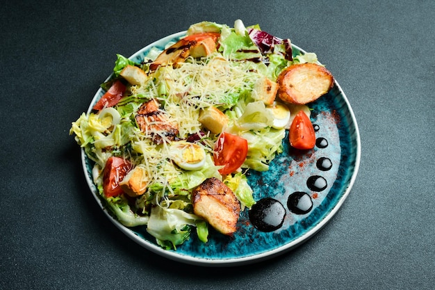 Caesar salad with chicken Restaurant menu On a dark background closeup